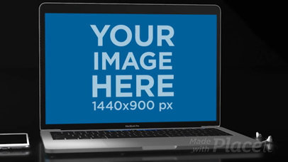 Video of a MacBook Pro Lying on a Flat Dark Surface Near an iPhone and Earpods a15822b