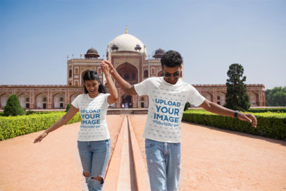 Matching Gildan T-Shirt Mockup Featuring a Couple Walking Near a Historical Monument